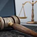 Gavel and balance scale on laptop computer