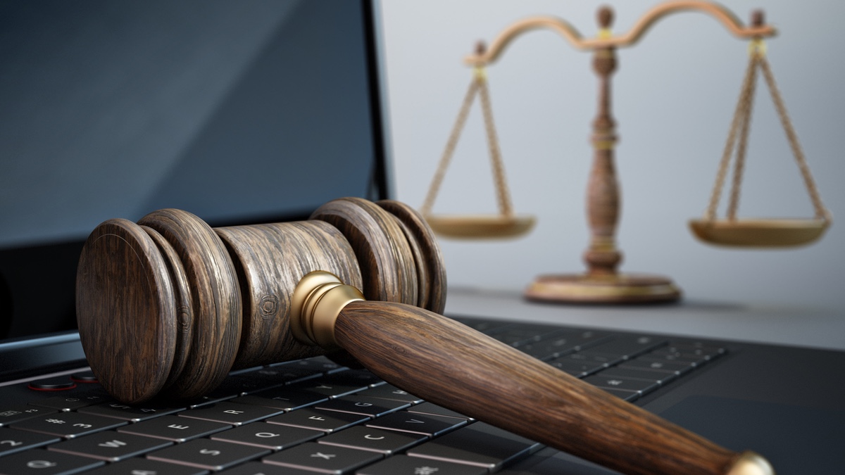Gavel and balance scale on laptop computer